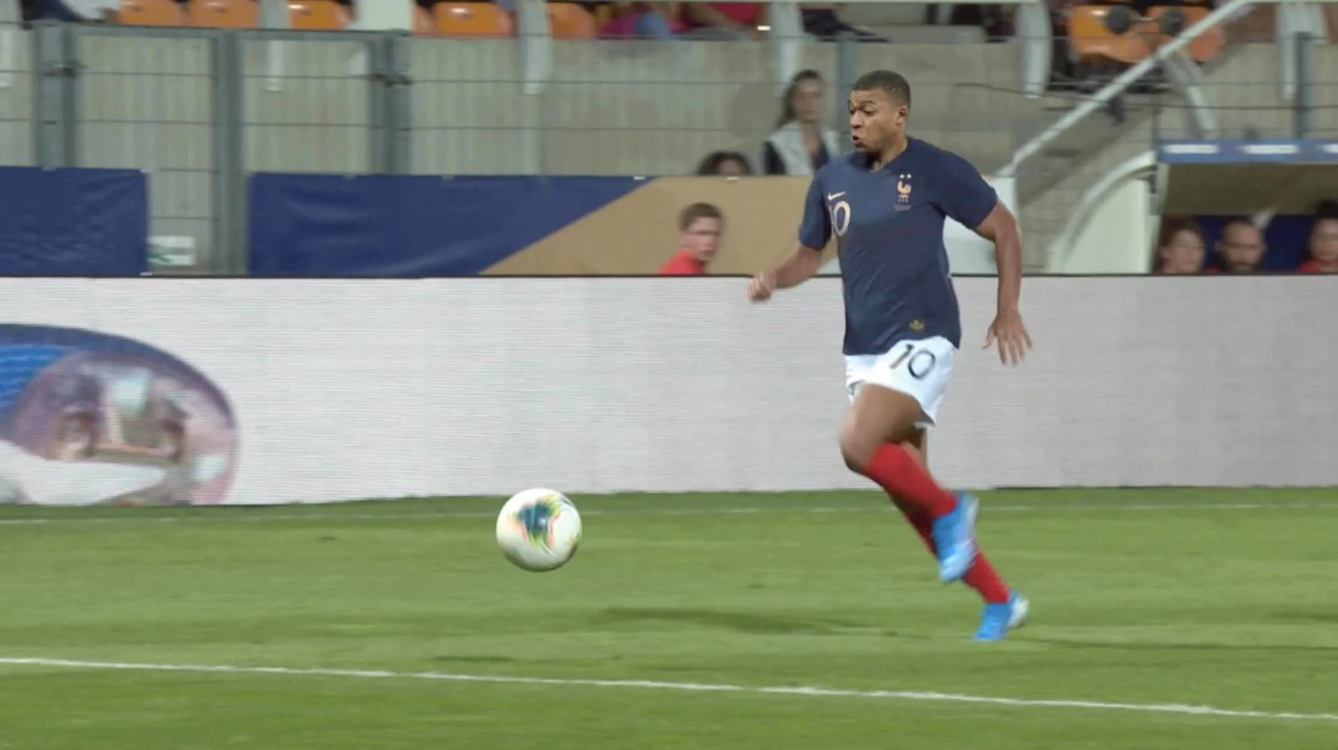 France football player in blue kit runs toward a ball in Orange’s Les Bleues campaign film.