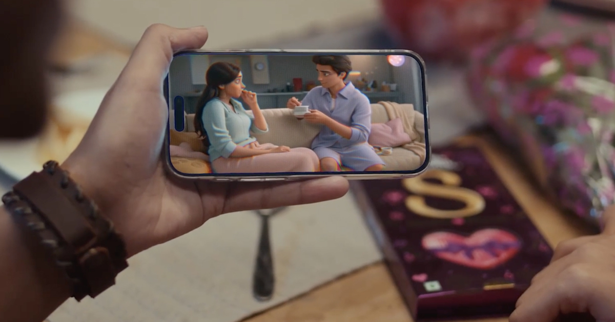 A phone shows an animated couple beside a Cadbury Silk box.