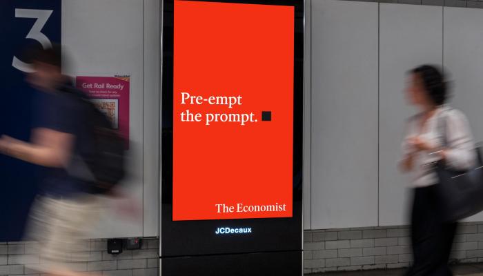 A white-on-red Economist poster references AI in a London station placement.
