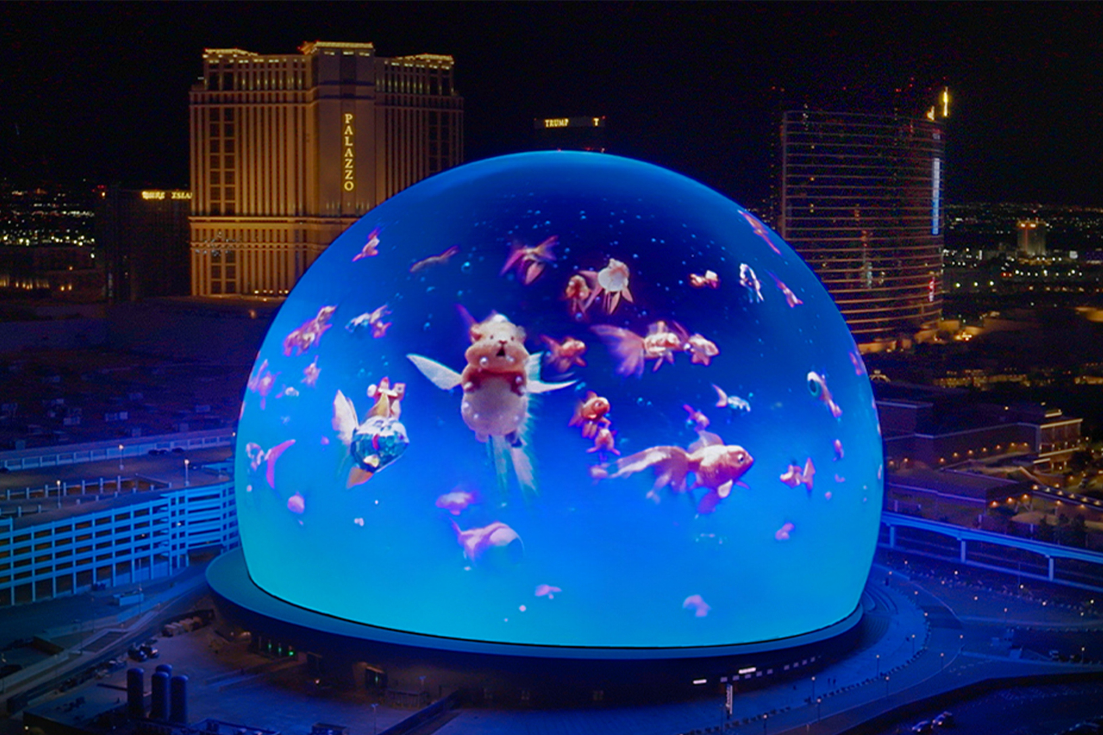 The Las Vegas Sphere is turned into a glowing blue fishbowl full of surreal fish.