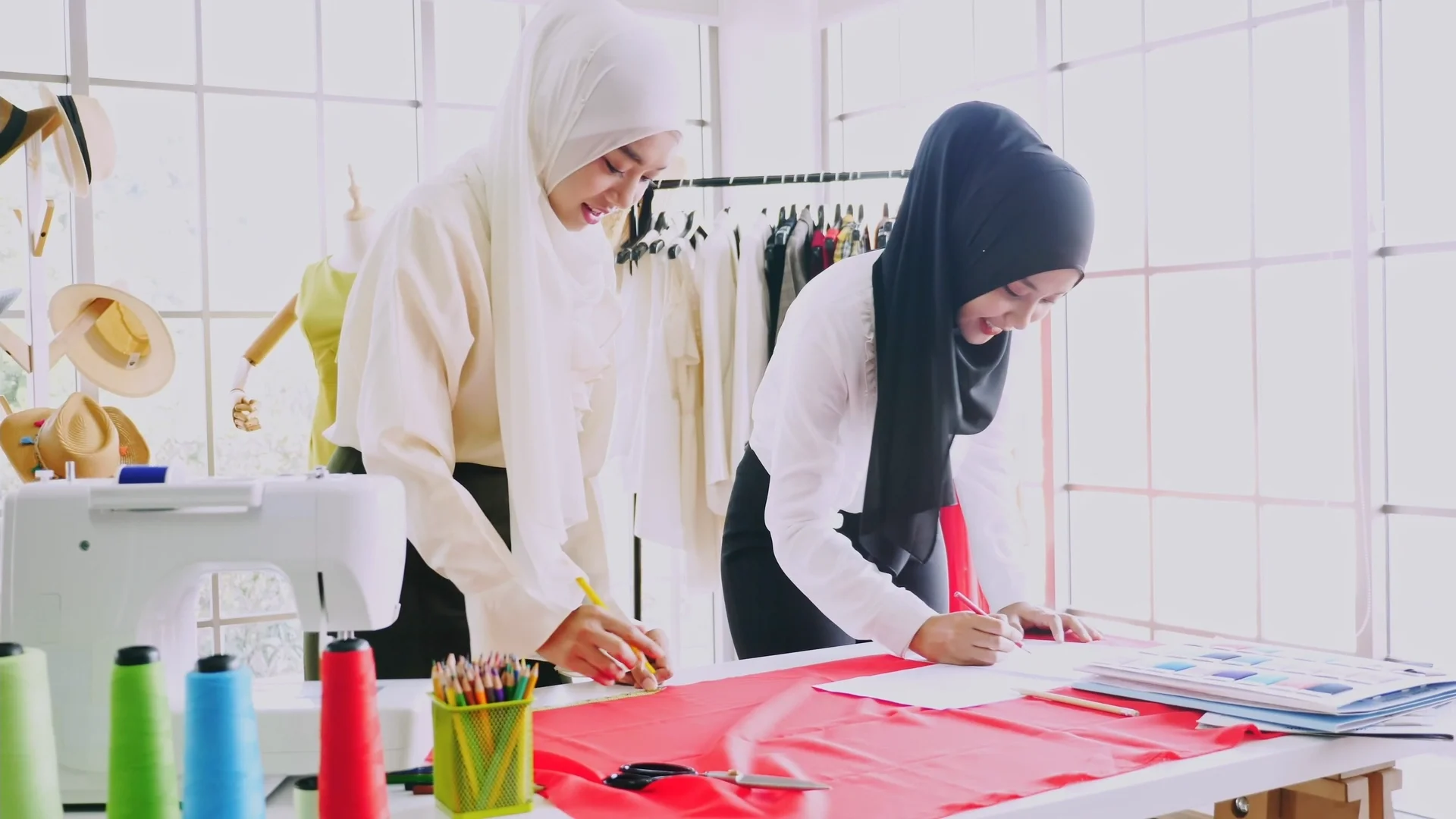 Two women in hijabs work at a table in a frame from the Vaseline Body Skin Check campaign video.